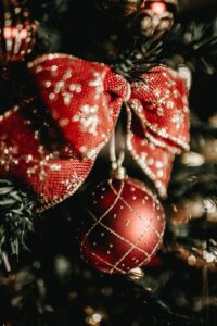 Close-up of a festive red Christmas ornament with gold accents on a decorated tree.